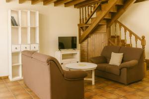 a living room with a couch and a tv at APARTAMENTOS MARIAJE in Barro de Llanes