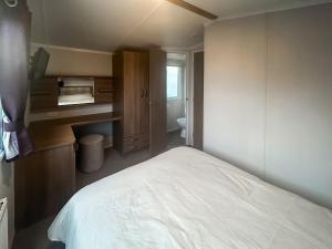 a bedroom with a white bed and a bathroom at Simon's Coastal Holiday Home in Ormesby Saint Margaret +11 photos