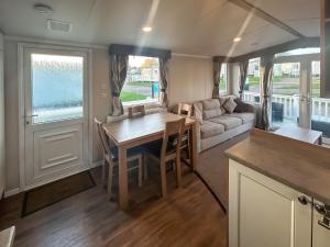 a kitchen and living room with a table and a couch at Simon's Coastal Holiday Home in Ormesby Saint Margaret