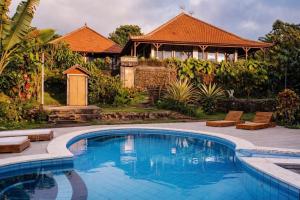 a swimming pool in a yard with a house at Manigelang Villa in Munduk