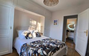a bedroom with a bed and a hallway with a bathroom at L'abri gascon in Auch