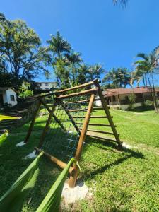 a wooden fence in a field with trees in the background at Chalé do Riacho Penedo in Itatiaia