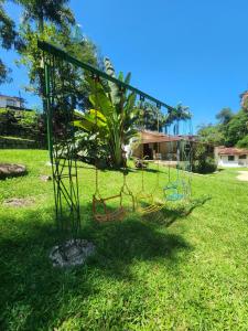 a swing set in a field of grass at Chalé do Riacho Penedo in Itatiaia