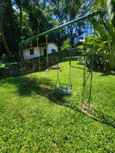 a swing set in the grass in a yard at Chalé do Riacho Penedo in Itatiaia +9 photos