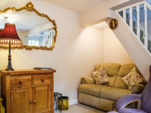 a living room with a couch and a mirror at Spire View Cottage in Olney