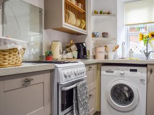a kitchen with a washer and a washing machine at Spire View Cottage in Olney