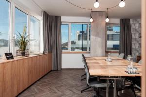 a dining room with a table and chairs and windows at Urban Ring Hotel in Ljubljana