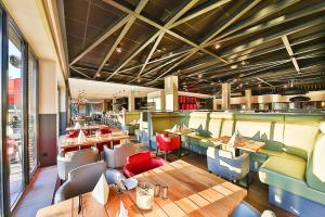 un restaurante con mesas y sillas de madera en See und Sporthotel Ankum Lakeside Apartments, en Ankum