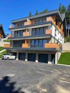 a building with a car parked in front of it at Apartment Moné - Kope in Slovenj Gradec