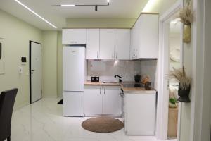 a kitchen with white cabinets and a sink at SSS Luxury Apartment with Jacuzzi in Kamëz
