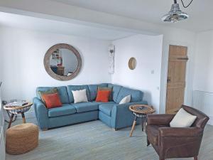 a living room with a blue couch and a mirror at Redgauntlet in Skinburness