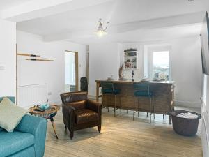 a living room with a blue couch and a table at Redgauntlet in Skinburness