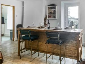 a kitchen with a wooden table with chairs around it at Redgauntlet in Skinburness