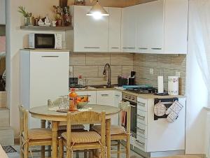 a kitchen with a table with chairs and a refrigerator at Casa Giovy in Roccastrada