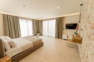a large bedroom with a large bed and a television at Aetheria South in Kourouta