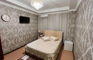a bedroom with a bed and a clock on the wall at Акерке Балхаш in Balqash