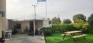 a backyard with a table and chairs and a house at שקט בערבה in Sappir