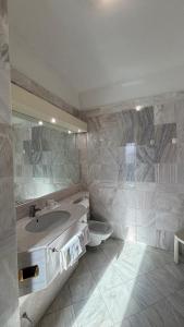 a bathroom with a sink and a toilet at Hotel Alexander Business and Conference in Abano Terme +25 photos