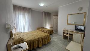a hotel room with two beds and a desk at Hotel Alexander Business and Conference in Abano Terme