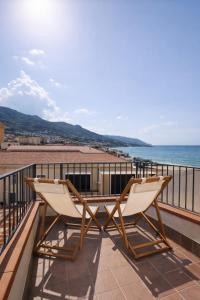 two chairs sitting on a balcony overlooking the ocean at Spinuzza Boutique Guesthouse Cefalù, Sicily in Cefalù