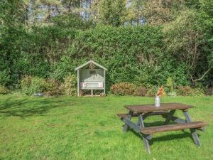 a picnic table and a doghouse in a yard at Shire Cottage - Uk50416 in Bisterne