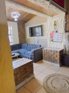 a living room with a blue couch and a table at Le Maire Gust Lodge in Johannesburg