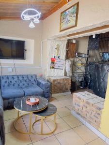 a living room with a blue couch and a table at Le Maire Gust Lodge in Johannesburg