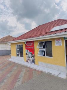 a small yellow building with a red roof at Le Maire Gust Lodge in Johannesburg