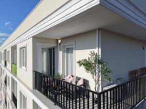 a balcony with a couch and a tree on it at SSS Luxury Apartment with Jacuzzi in Kamëz
