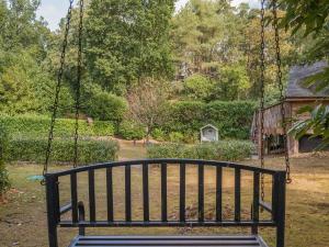 a swing seat in a yard with a house at The Lodge - Uk50409 in Bisterne