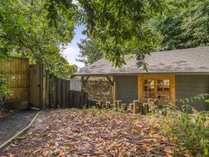 a house with a fence and a yard with leaves at The Lodge - Uk50409 in Bisterne