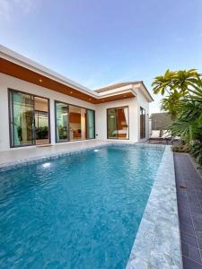 a swimming pool in front of a house at Vela Villa Aonang in Ban Chong Phli