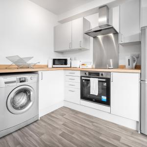 a white kitchen with a washer and dryer at Stylish Two Bed Apartment - Parking - Sleeps 3 - Netflix 55C in Sleightholme