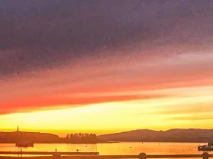 a sunset over a body of water with the sky at Airds Apartment in Oban