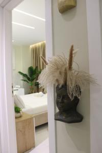 a statue of a head with a feather hat on a wall at SSS Luxury Apartment with Jacuzzi in Kamëz +64 photos
