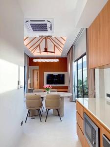 a kitchen with a table and chairs in a room at Vela Villa Aonang in Ban Chong Phli