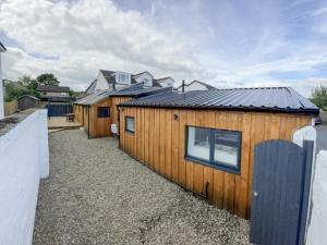 a row of wooden buildings with a fence at Ardrhu Cottage in Hunters Quay