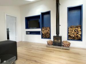 a living room with a wood stove and a tv at Ardrhu Cottage in Hunters Quay