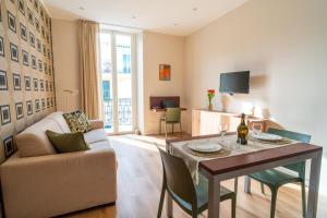 a living room with a table and a couch at Sul Corso Sanremo in Sanremo