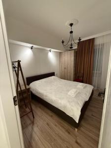 a bedroom with a bed with white sheets and a chair at Cozy Newly Renovated Apartment in Batumi Old Town in Batumi