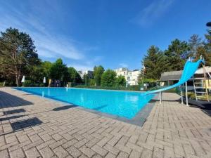 a blue slide in the middle of a swimming pool at Le Ptit studio du vieux moulin in Rochefort