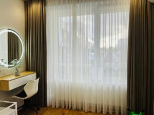 a bathroom with a window with a white curtain at Apartament white in Chişinău