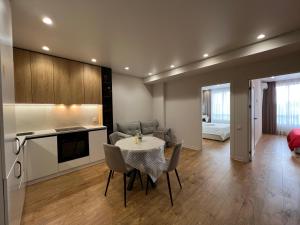 a kitchen and living room with a table and chairs at Apartament white in Chişinău