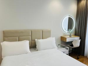 a bedroom with a white bed and a mirror at Apartament white in Chişinău