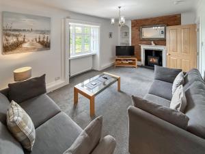 a living room with two couches and a fireplace at Church View in Hunstanton