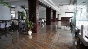 a dining room with tables and chairs and plants at Відпочинковий - комплекс '"Замок Лева"" in Peremyshlyany