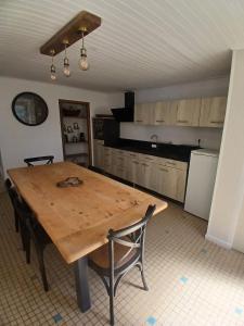 a kitchen with a wooden table in a room at Le Gîte de la Gartempe in Saint-Sornin-la-Marche