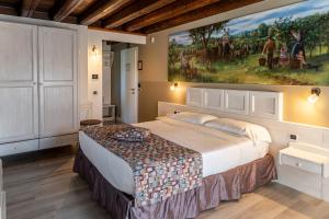 a bedroom with a large bed with a painting on the wall at Il Roncal Wine Resort - for Wine Lovers only in Cividale del Friuli