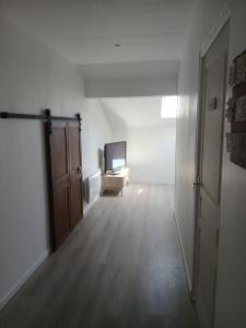 an empty room with a television and a wooden floor at Le Gîte de la Gartempe in Saint-Sornin-la-Marche +6 photos