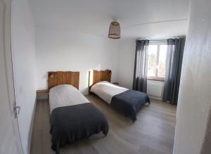 a room with two beds and a window at Le Gîte de la Gartempe in Saint-Sornin-la-Marche
